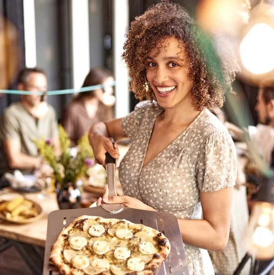 RVS pizzaschep met gaatjes, gebruikt om pizza op te tillen