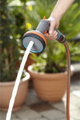 Gardena broeskop met 5 standen in hand, sproeiwater uit grijze oranje spuitkop