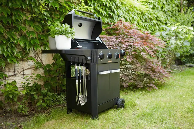 Zwarte gasbarbecue op wielen met zijplank, gereedschaphaken en bedieningsknoppen