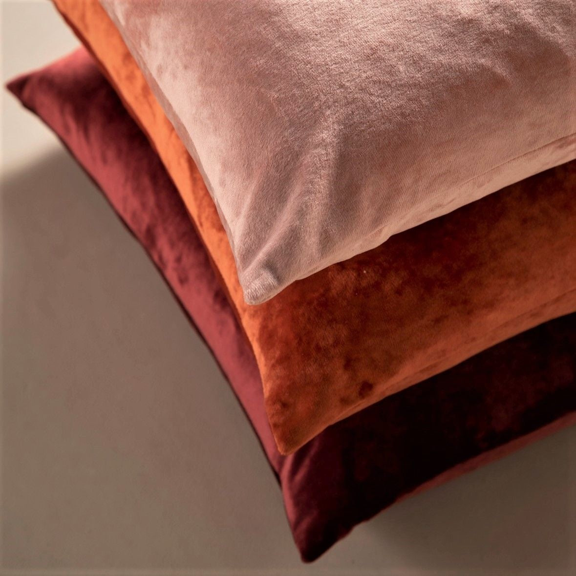Set sierkussens: terracotta en donkerrood, in stapel met effen suède-achtige stof