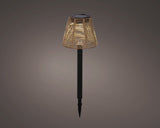 Solar steeklamp met rieten kap en zwarte paal, zonnecelmodule op de bovenkant.
