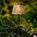 Solar steeklamp met rieten lampenkap op zwarte prikkerpaal.