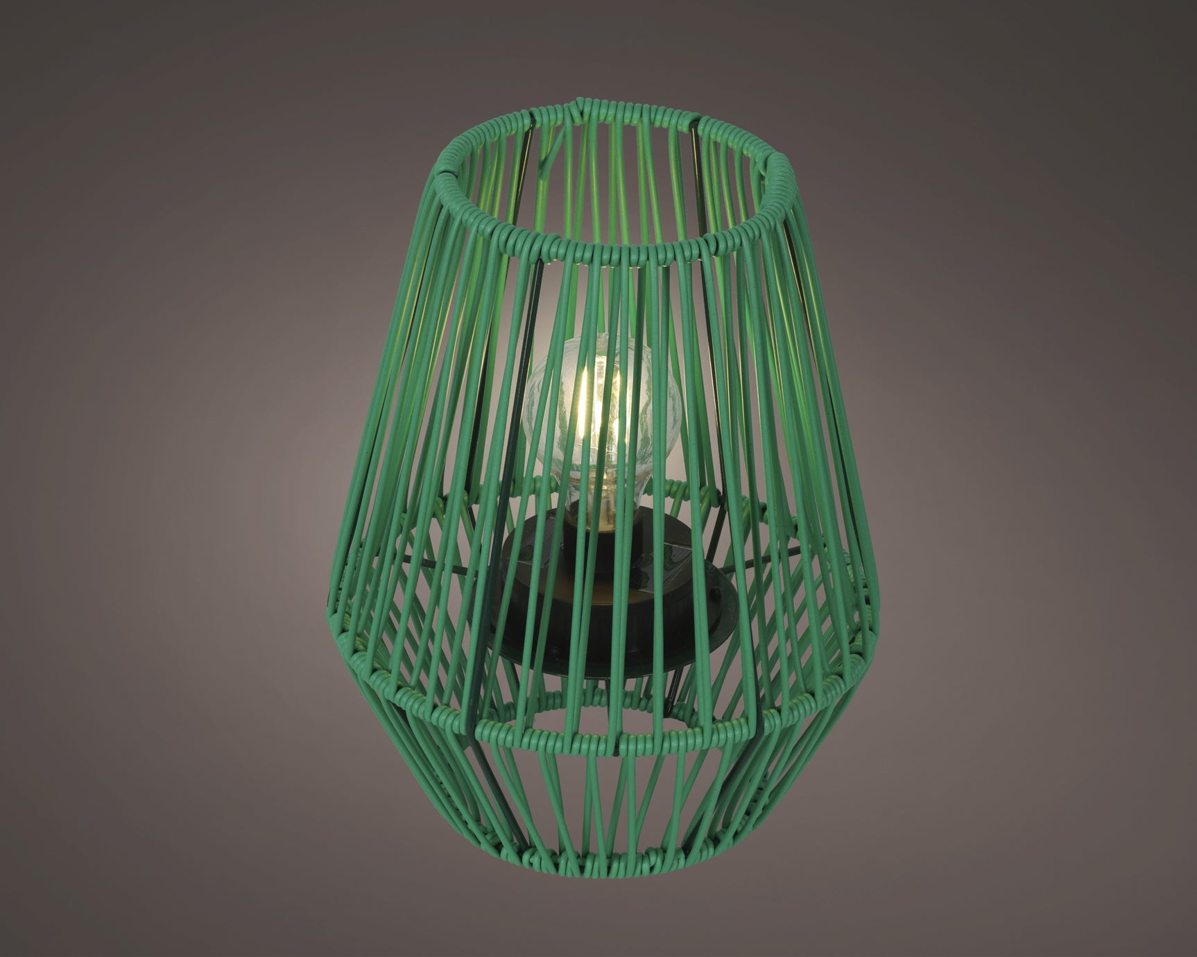Groene rieten solar lantaarn van voren, open draadstructuur rondom.