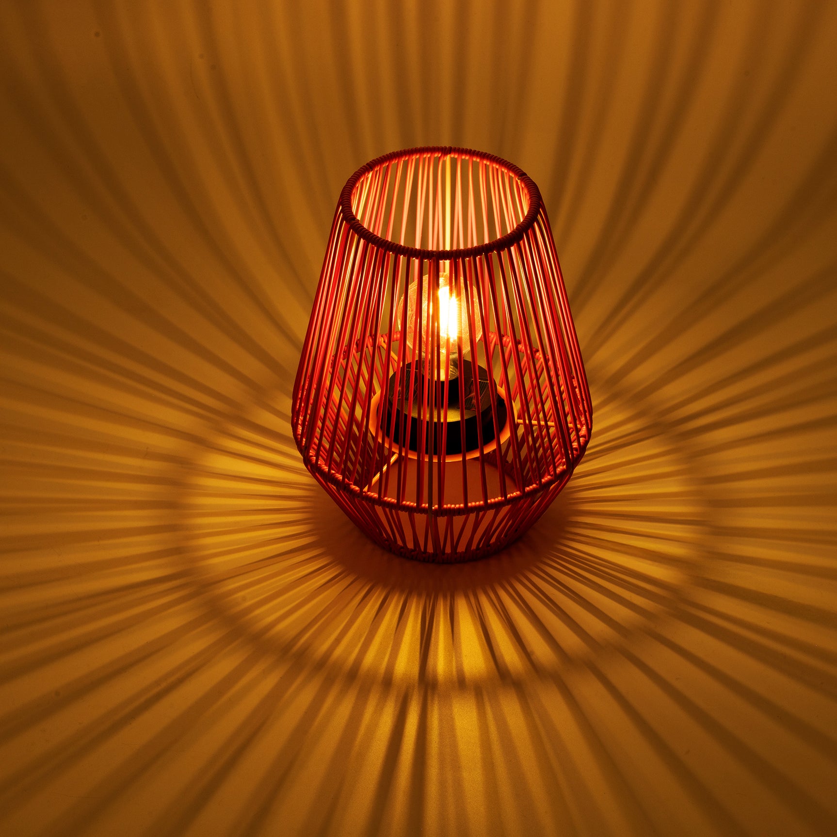 Zonne-lantaarn rotan mand, roodachtig roze draad, brandend lampje