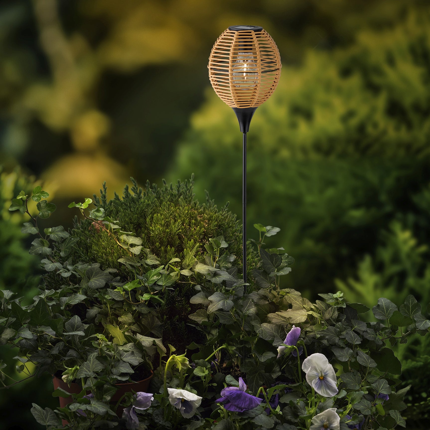 Solar tuinprikker met rieten bol-lantaarn, geplaatst tussen bloeiende planten
