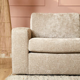 Beige bank, brede zitting en rugkussen met grove stofstructuur
