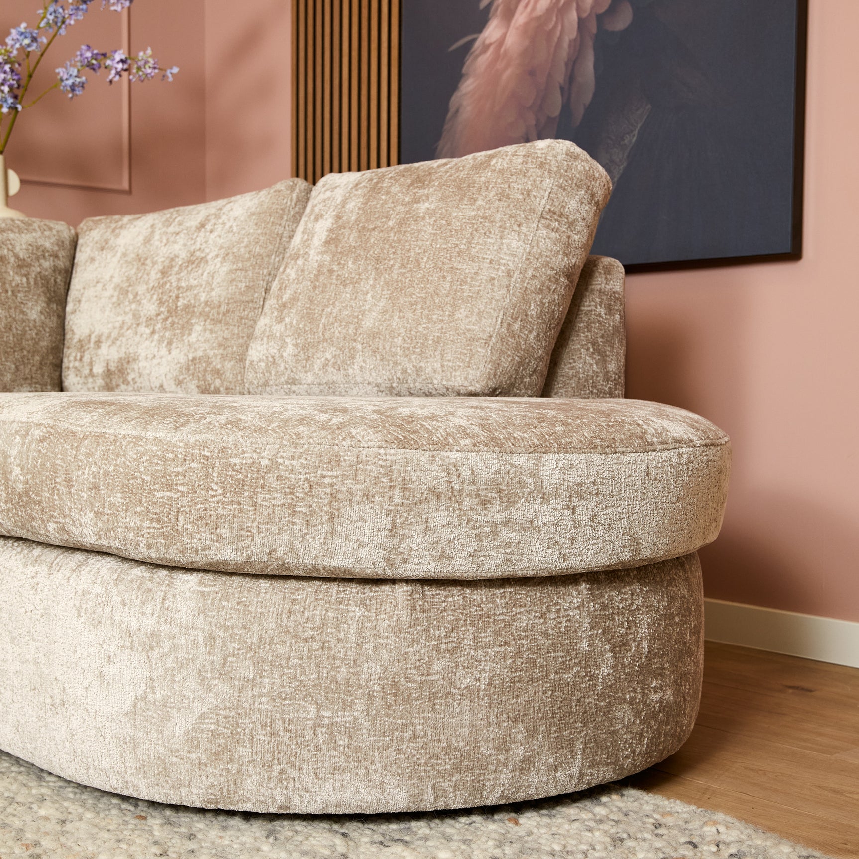 Beige ronde chaise op bank, zachte stof en hoge rugkussens