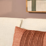 Beige bankzitting met grove stof, siernaad en rode sierkussenhoek