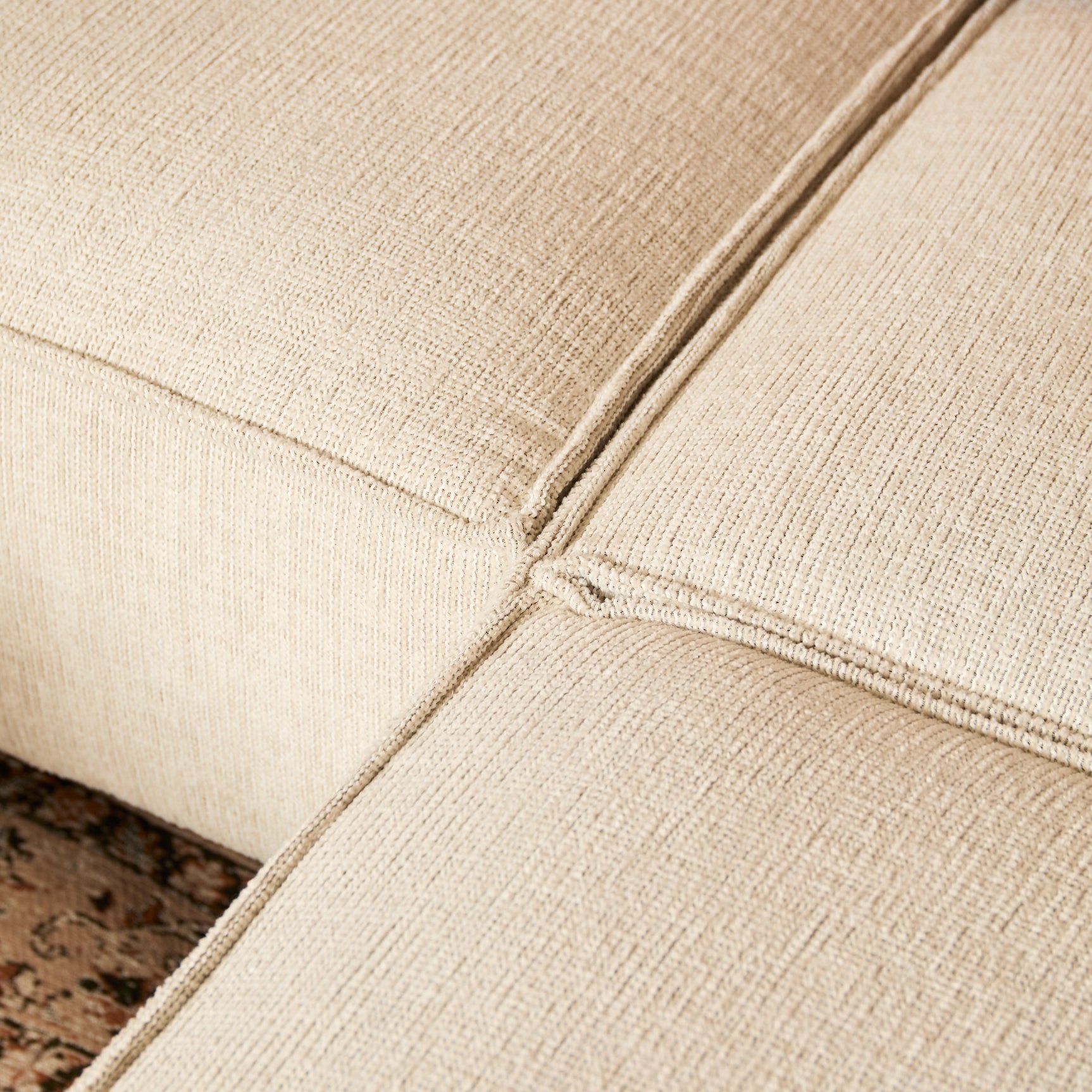 Beige bankhoek met zichtbare stiknaad en grove geweven stof