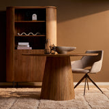 Zijaanzicht ronde eettafel in naturel hout met centrale ribbelsokkel en stoel