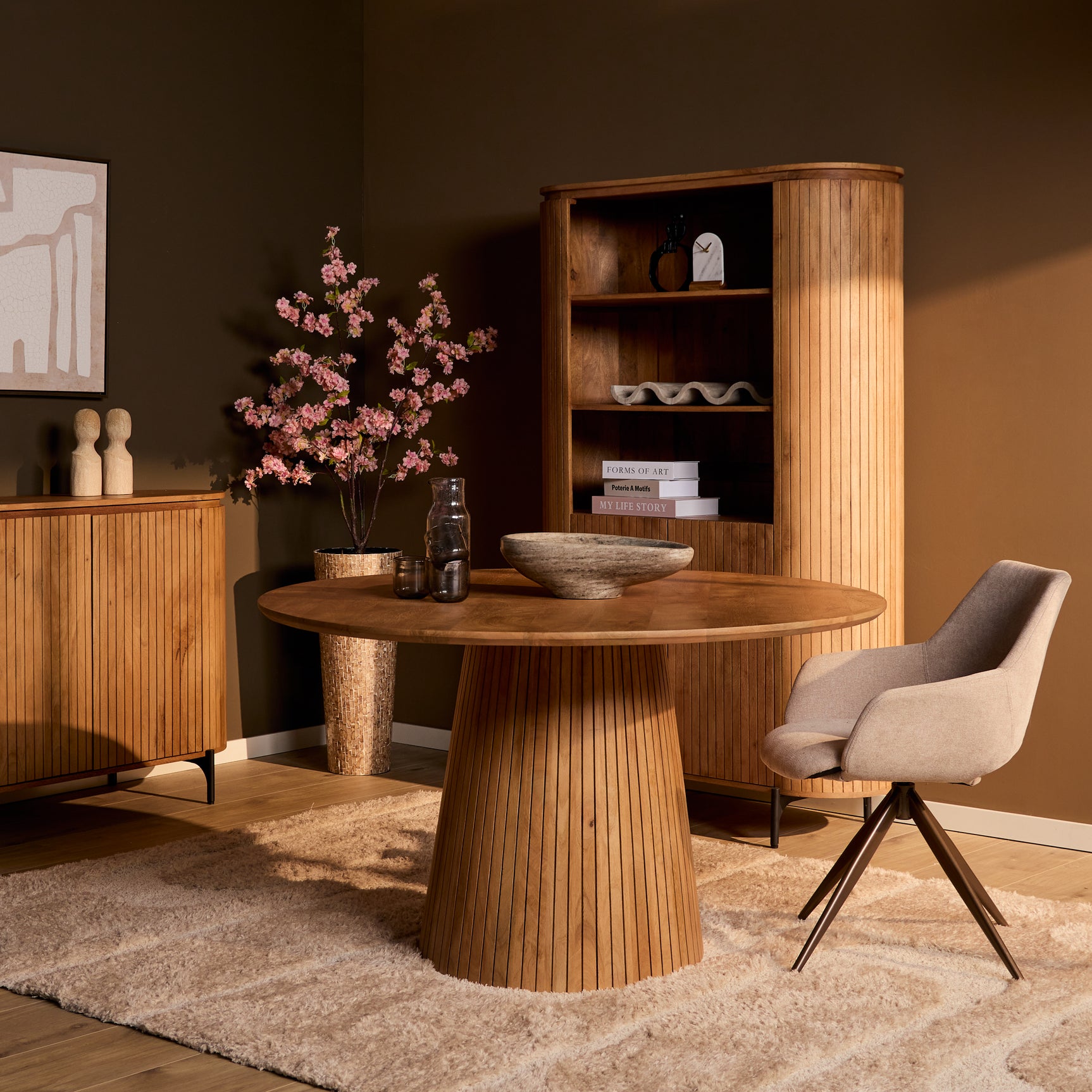 Ronde naturel houten eettafel met centrale ribbelsokkel en eetstoel in eetkameropstelling