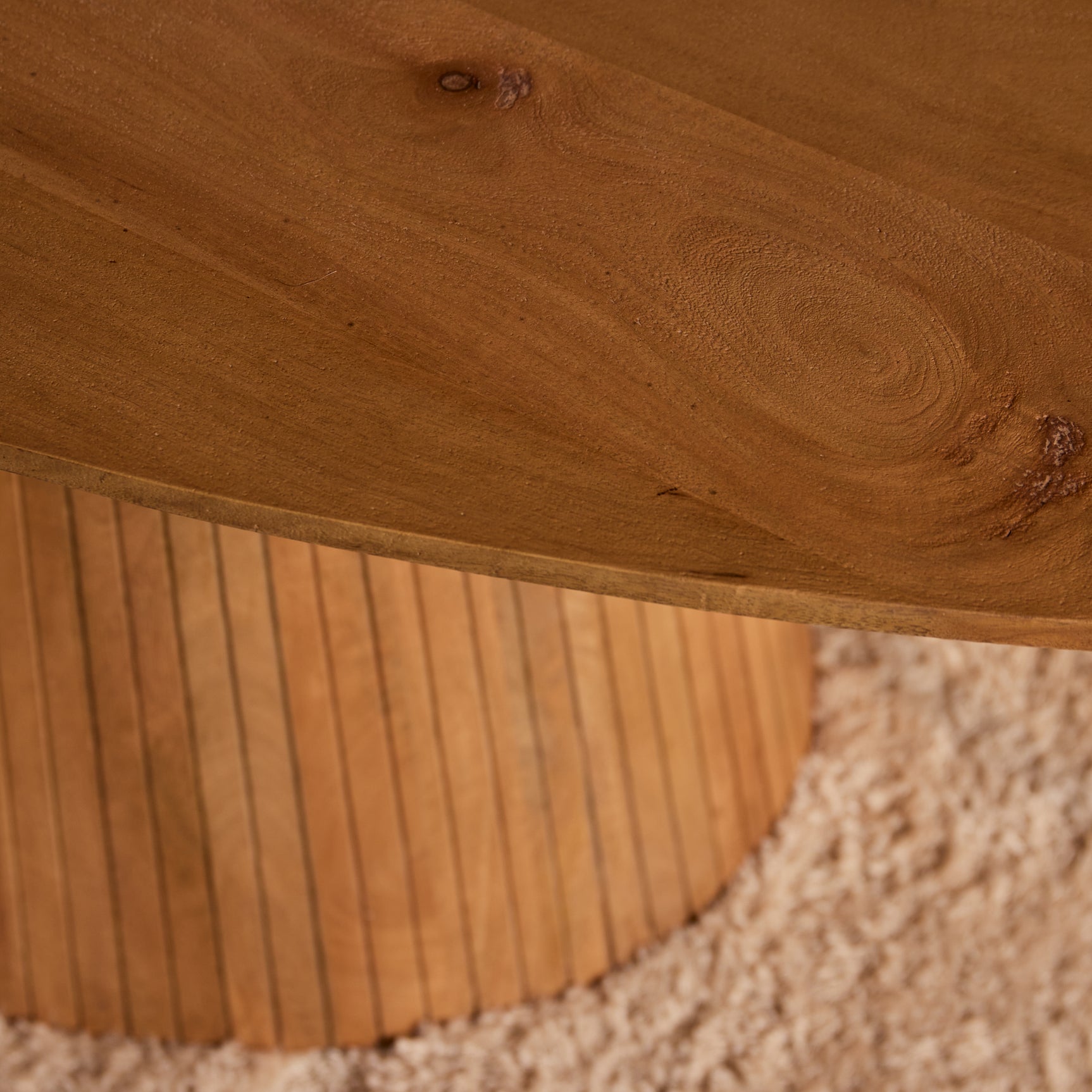 Eettafel Solana: close-up van rond houtnerf blad en geribbelde tafelpoten, naturel