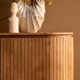 Dressoir close-up: verticale houtlatten in naturel op frontpaneel met gladde bovenrand.
