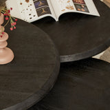Ronde zwarte salontafel met zichtbare houtnerf en gebogen rand