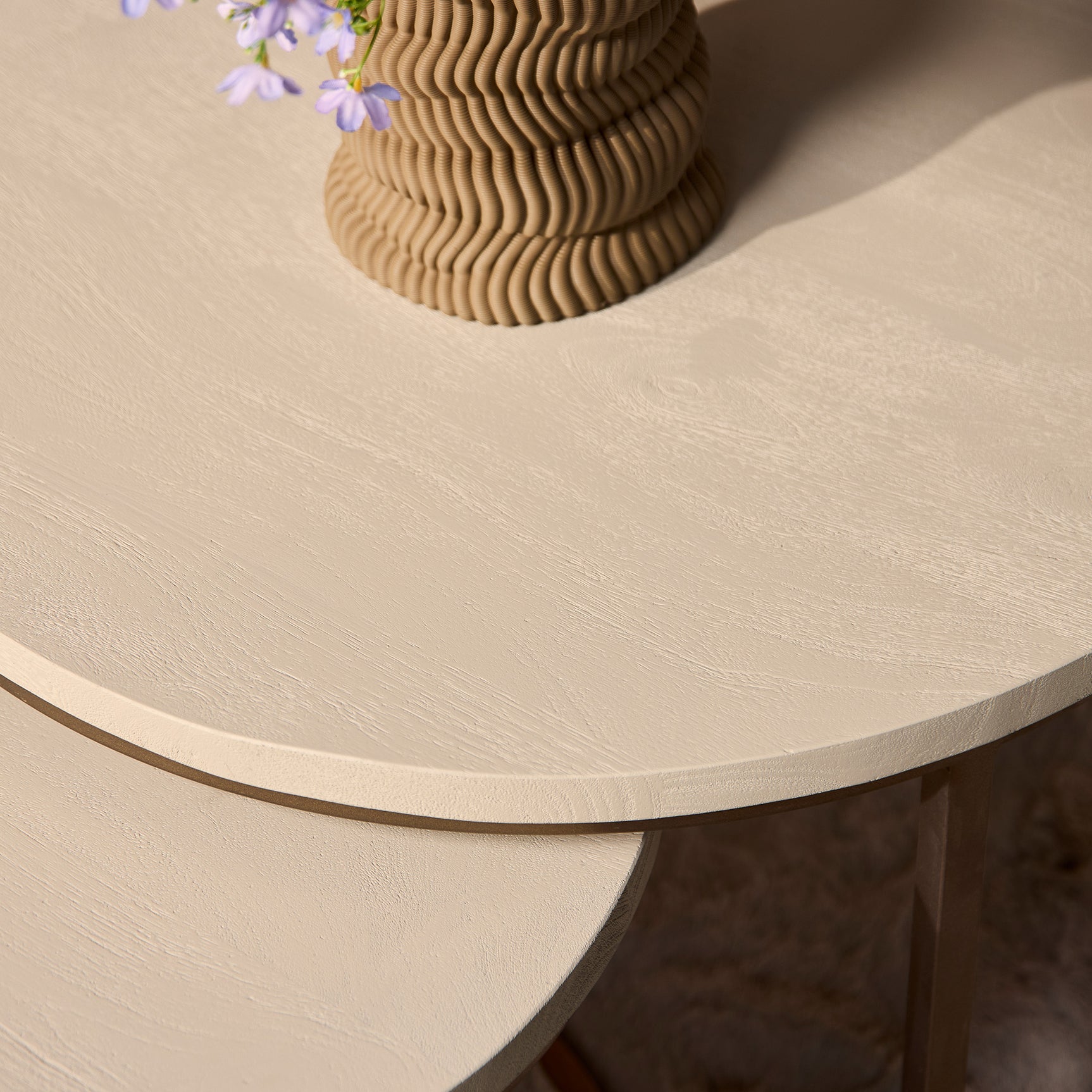 Ronde zandkleurige salontafel met decoratieve houtnerf en donkerbruine rand