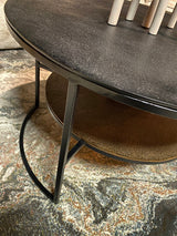 Zwarte ronde salontafel met metalen onderstel en gebogen zwarte poot, onderplank