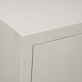 Dressoir-detail van hoek en deurpaneel, strakke lijnvoering en lichtgekleurde afwerking.