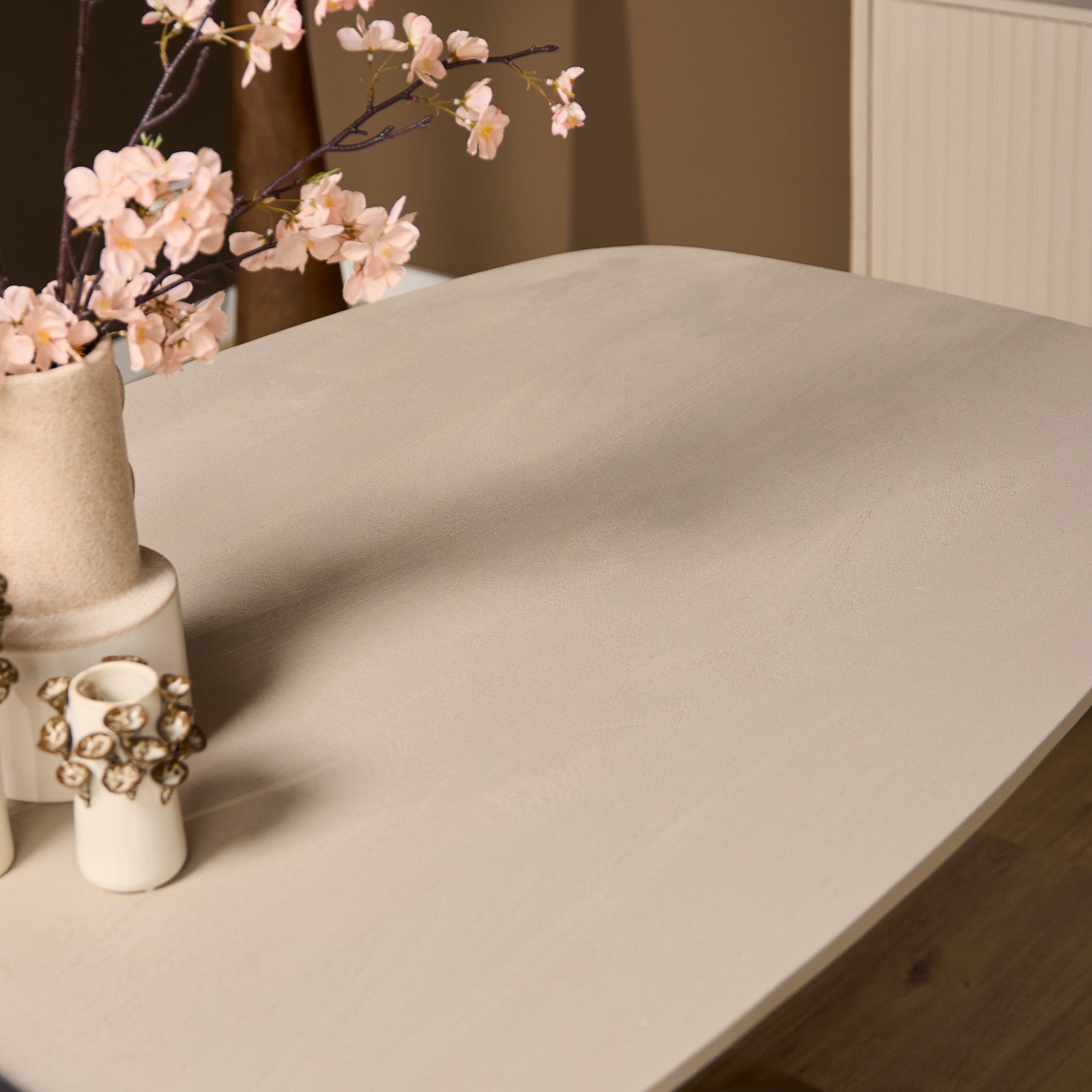 Ovale eettafel met zandkleurig blad en afgeronde hoeken