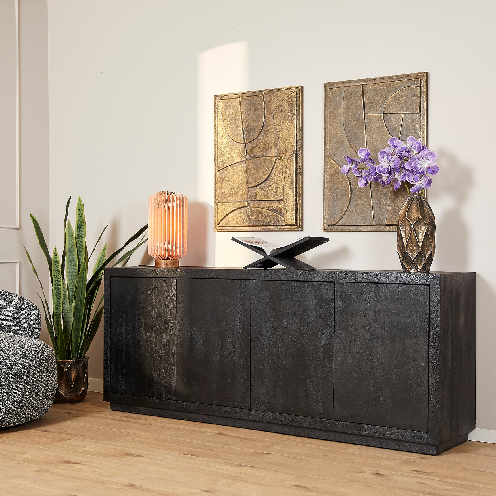 Zwart dressoir met paneeldeuren en strakke greeplijsten, brede frontplaat.