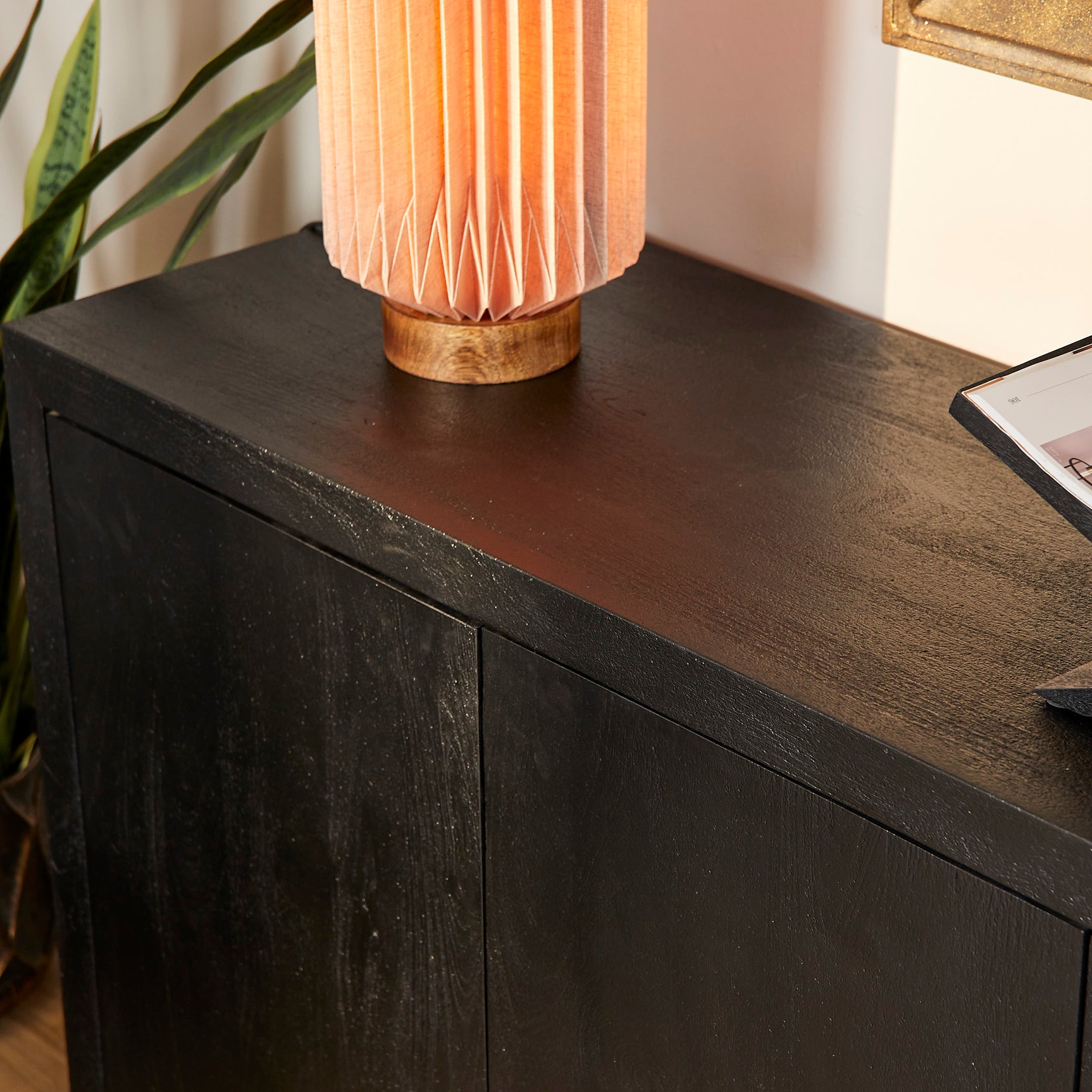 Zwart dressoir bovenblad en frontpanelen met houtnerf, vier deurbakken.