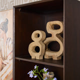Bruine boekenkast met open bovenruimte en decoratieve houten figuren op plank.