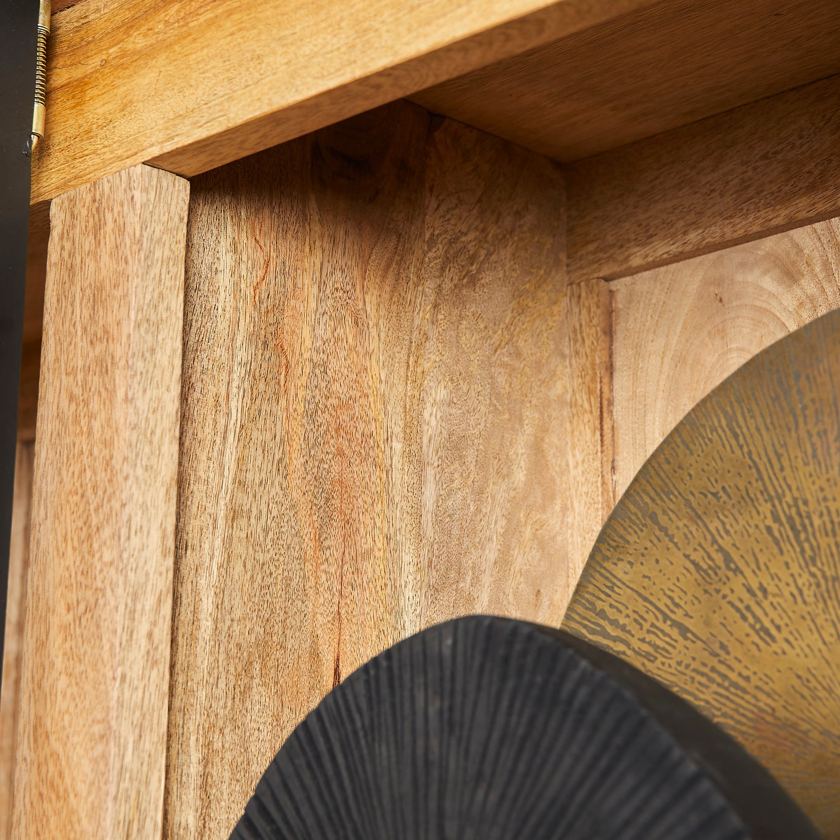 Houten kastwand met nerfstructuur en zwarte metalen rand, detail van een open vak
