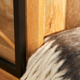 Zwarte zijstijl en houten plank met lichte wollen stofrand, detail van hoek