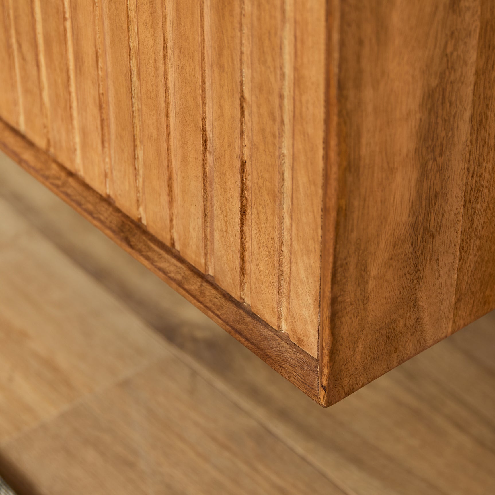 Zwevend tv-meubel, close-up van naturel houten zijkant met verticale nerf