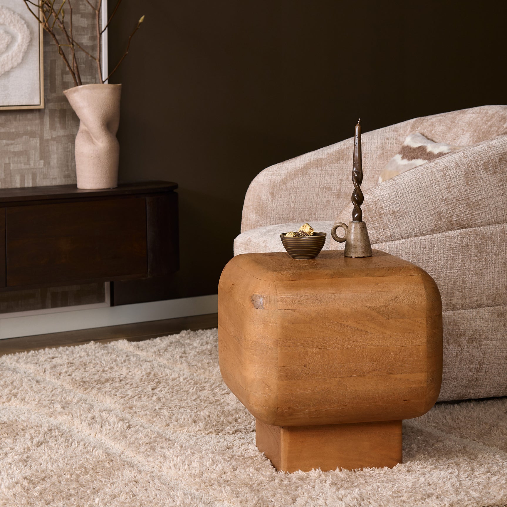 Houten bijzettafel met decoraties, kaars en kom op afgerond houten blad