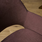 Eetkamerstoel met mauve stoffering, zichtbare naad en gebogen armleuning.
