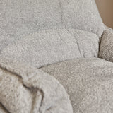 Lichtgrijze fauteuilbekleding met grove stofstructuur en gestikte naad langs rugkussen.