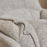 Lichtgrijze fauteuilbekleding met plooi en grove stofstructuur, gestikte rand.
