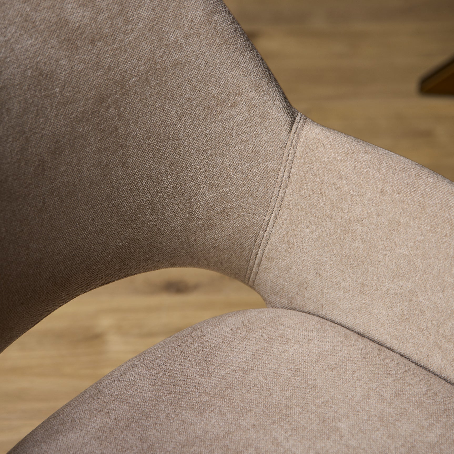 Beige gestoffeerde rug en zitting van eetkamerstoel, met zichtbare naad