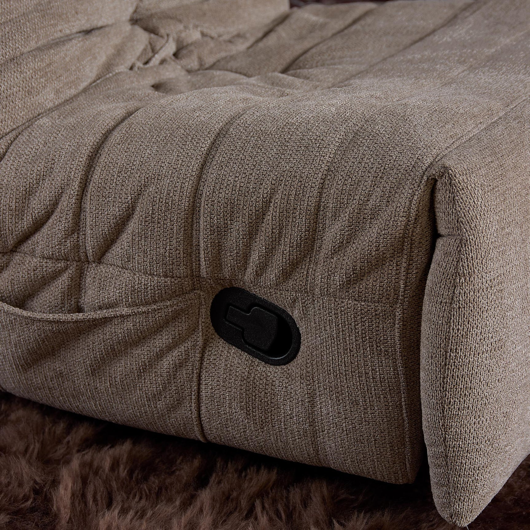 Taupe relaxfauteuil met zwarte bedieningsknop en gestoffeerde zijkant
