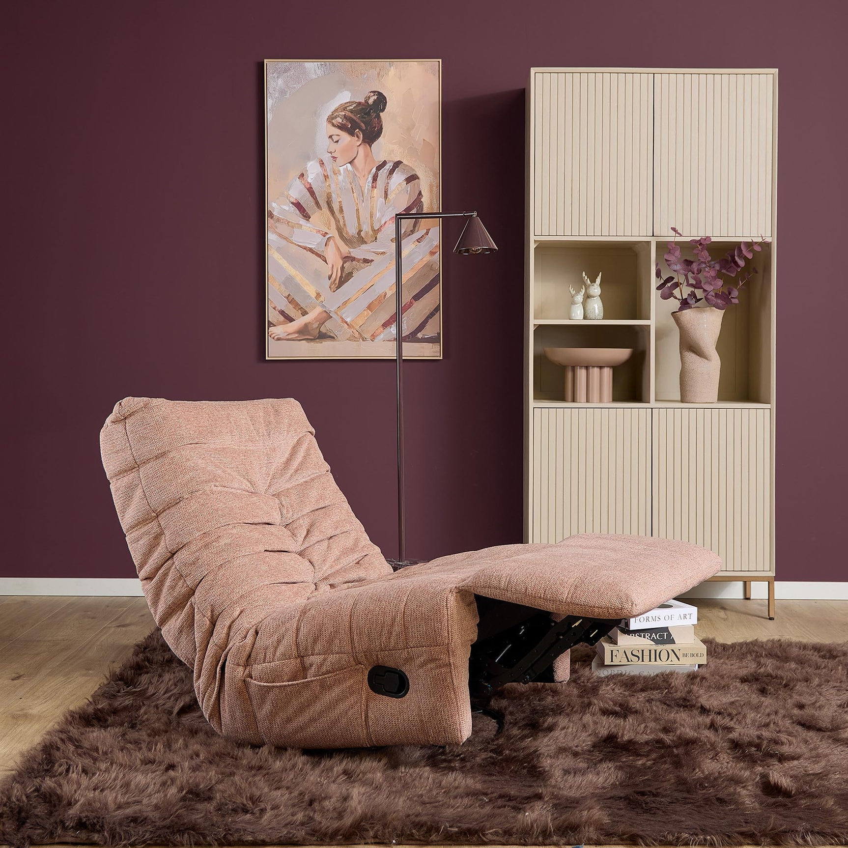Roze relaxfauteuil met volledig open ligstand, gestoffeerde rug en zwarte bediening.