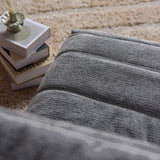 Grijze relaxfauteuil met ribstructuur in de stoffen zitting en rug