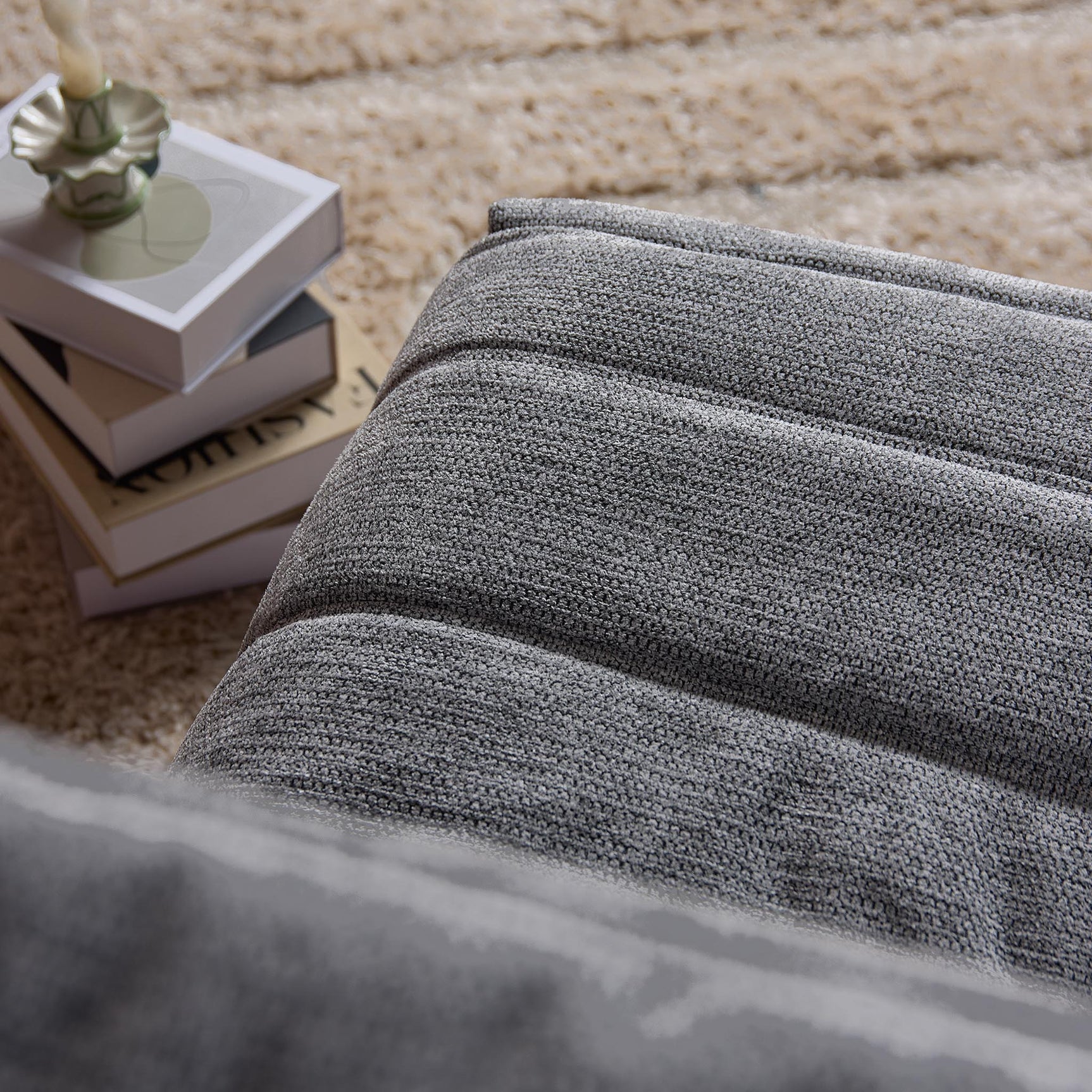 Grijze relaxfauteuil met ribstructuur in de stoffen zitting en rug