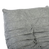 Grijze relaxfauteuil rug met gestikte banen en knoopdetails, gladde stof.