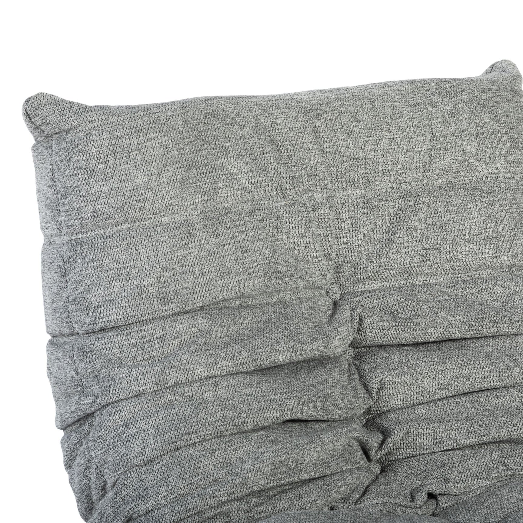 Grijze relaxfauteuil rug met gestikte banen en knoopdetails, gladde stof.