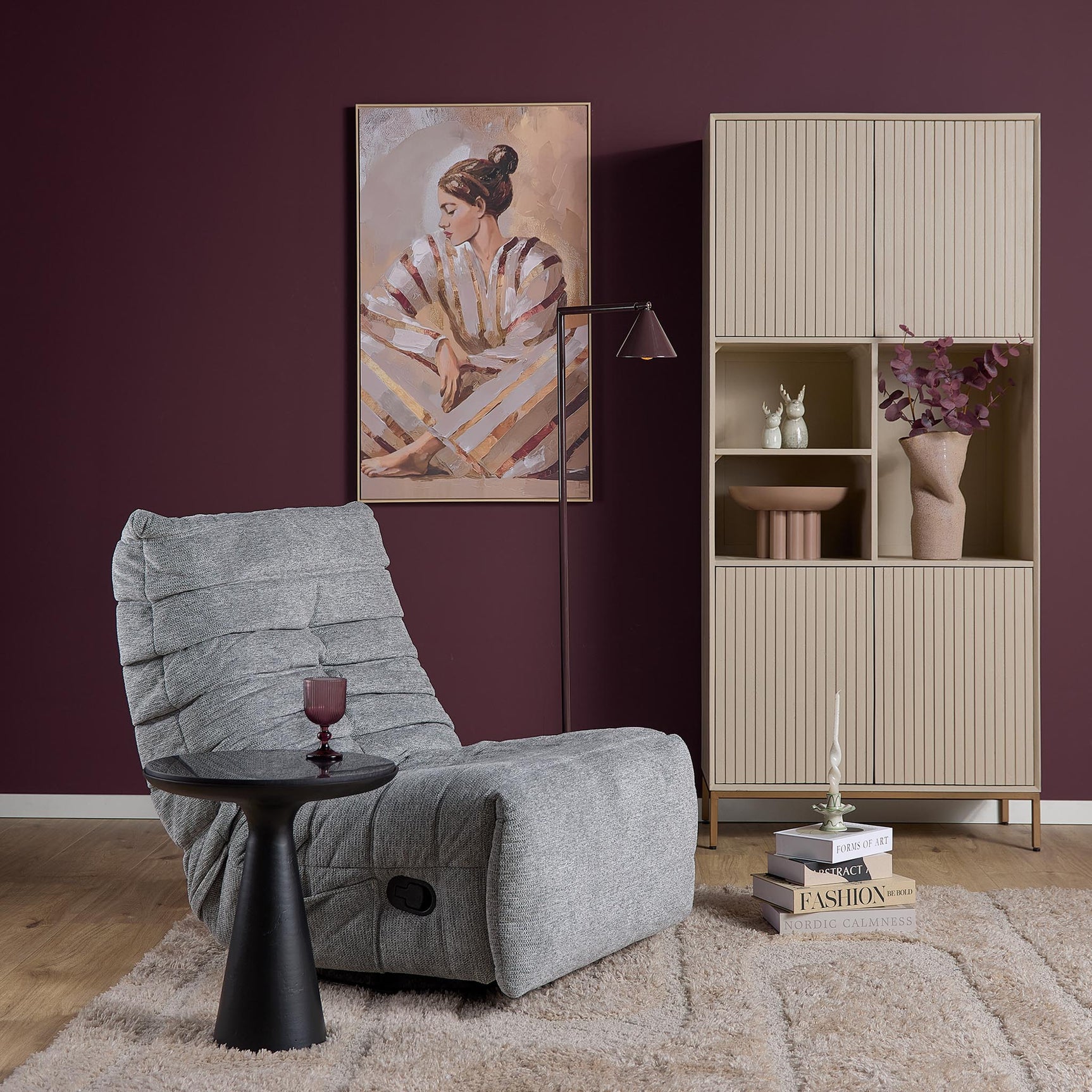 Grijze relaxfauteuil in hoekopstelling met ligstand en voetensteun, ronde basis.
