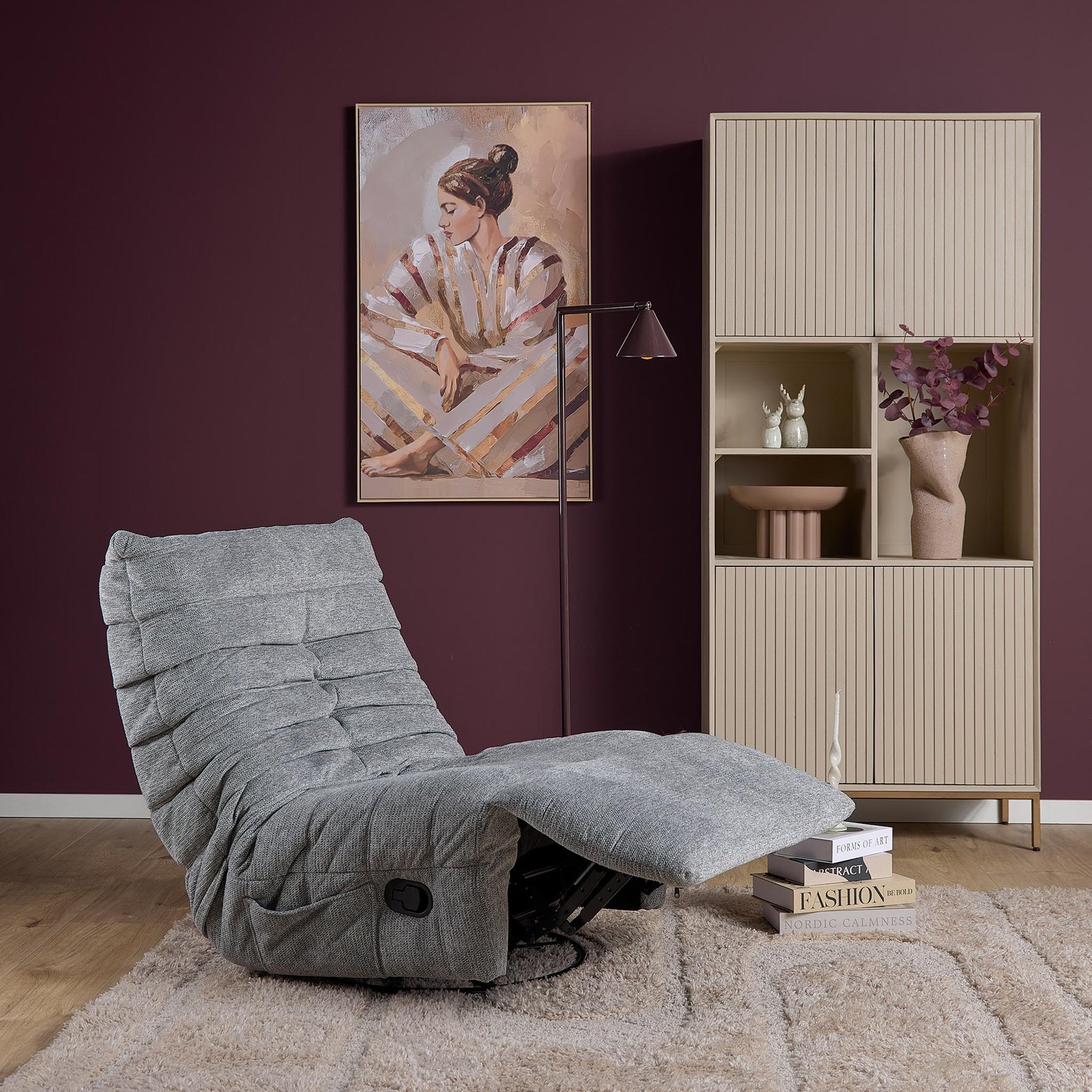 Grijze relaxfauteuil met ligstand en uitklapbare voetensteun, gewatteerde rugkussens.