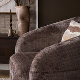 Fauteuil Yara met beige stoffering, close-up van afgeronde arm en gestoffeerde rug