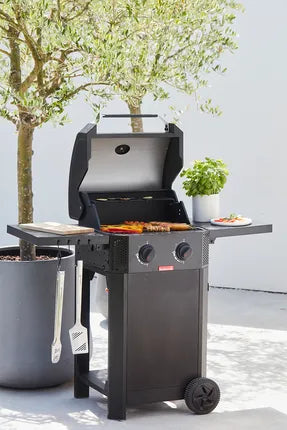 Zwart gasbarbecue met open deksel en gegrilde groenten en vlees