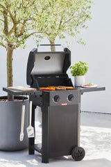 Zwart gasbarbecue met open deksel en gegrilde groenten en vlees