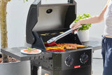 Gasbarbecue met open deksel en rooster met etenswaren, hand met tang