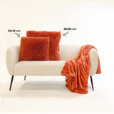 Sierkussen 60x60 cm met pluizige shag, oranje, op beige bank