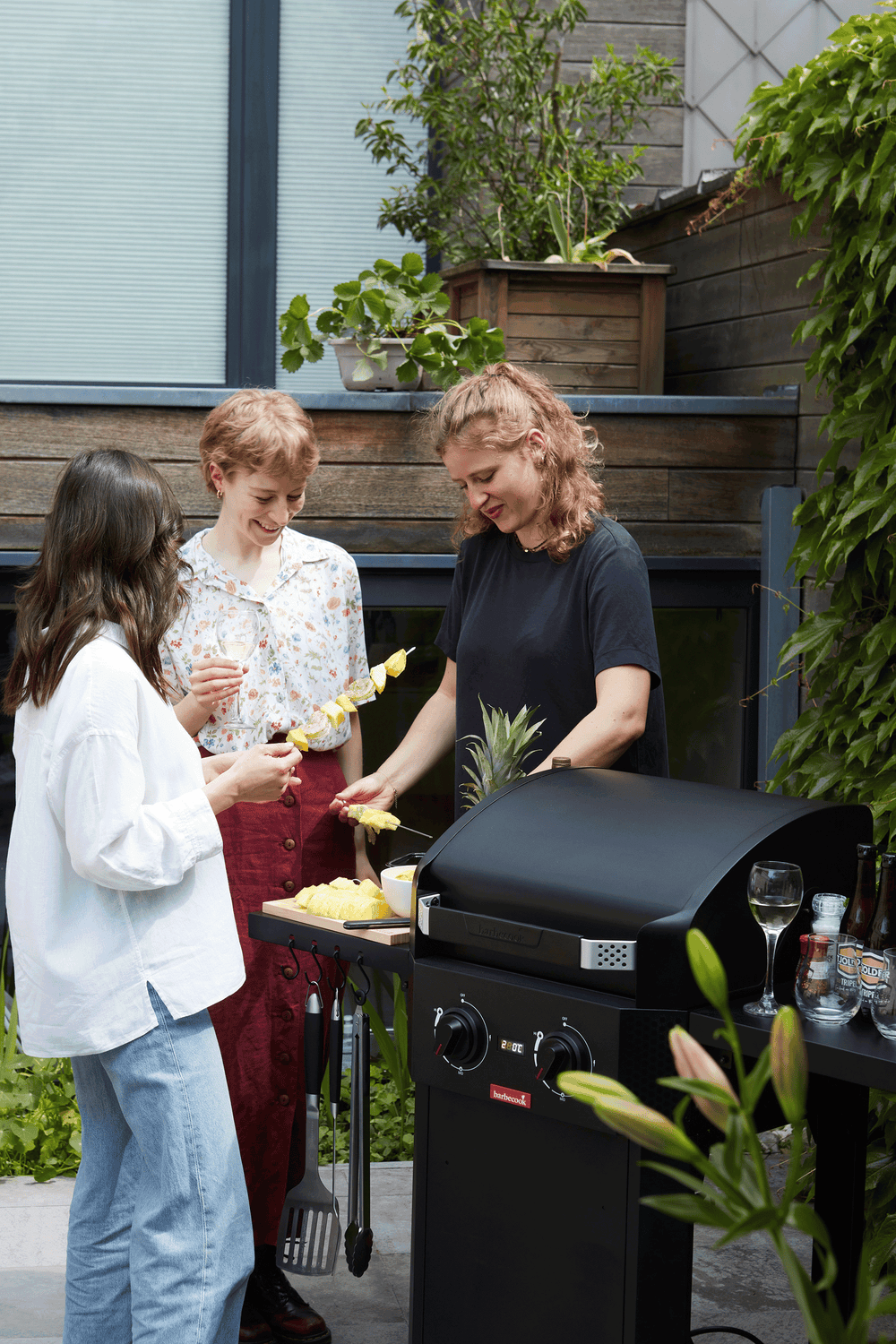 Zwarte elektrische barbecue met open deksel en gegrilde etenswaren op het rooster