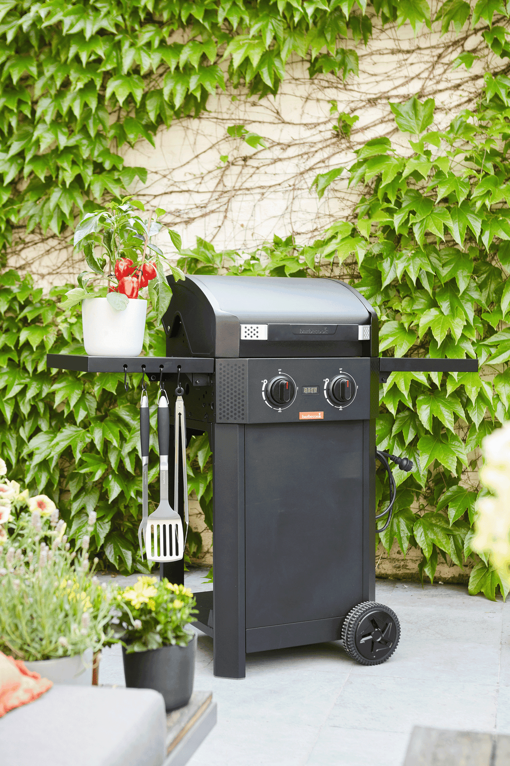 Zwarte elektrische barbecue op wieltjes met roosterkookplaat en knoppen