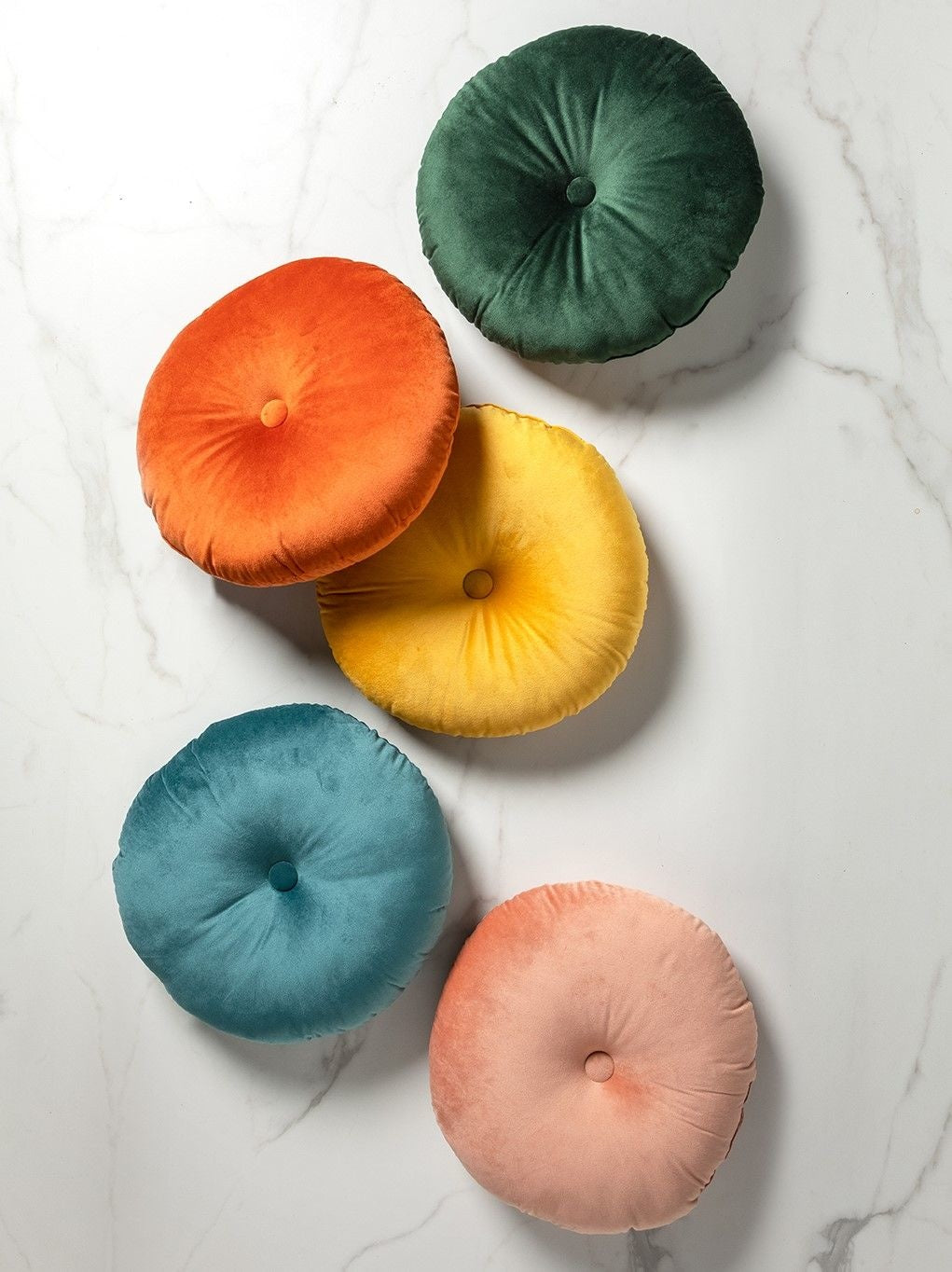 Set ronde sierkussens in groen, oranje, geel, blauw en roze met knoopdetail.